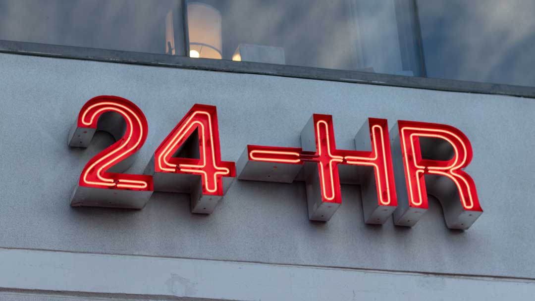 open 24 hours neon red sign on building